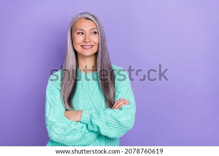 Photo of cheerful mature lady curious look empty space clever imagination isolated over violet color background