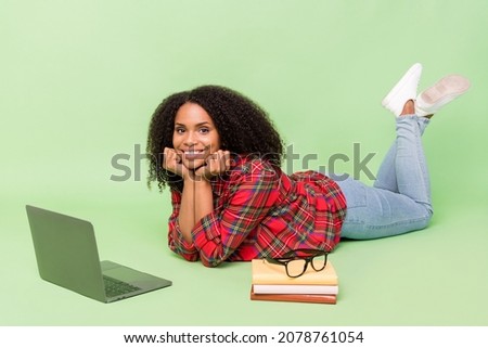 Full size profile side photo of young african lady lying floor use laptop courses knowledge isolated over green color background
