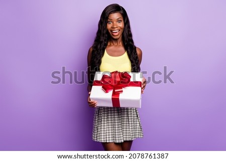 Photo of impressed nice curly hairdo lady hold present wear top skirt isolated on vibrant purple color background
