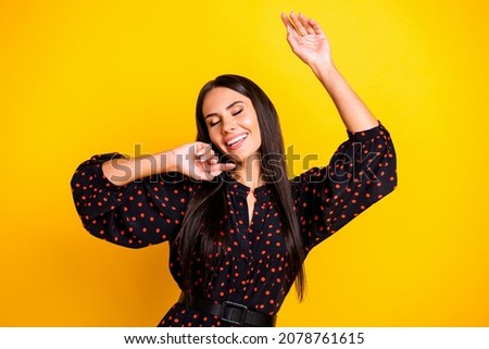 Photo of charming cute young lady dressed black clothes dancing closed eyes isolated yellow color background