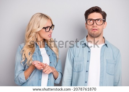Photo of annoyed angry young people wear denim shirts glasses quarreling isolated grey color background