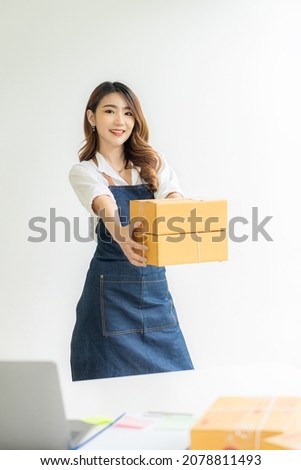 Asian woman starting a small SME business working on boxes and laptops preparing parcels for shipping. and the concept of working from home, collecting parcels, packing boxes in vertical order