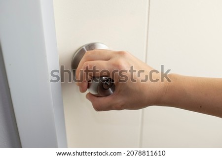 Opening the door, close-up and picking a person's hand which is a doorknob on the handle