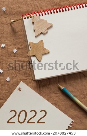 Notepad with blank white sheets on a brown background. Write a letter. Winter atmosphere. top view