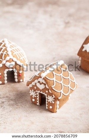 Three mini gingerbread houses on a beige background. Christmas concept.