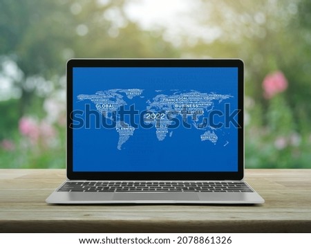 Start up 2022 business icon with words world map with laptop computer on table over blur flower, Happy new year 2022 global business start up online concept, Elements of this image furnished by NASA