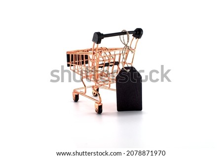 Black sale tag and golden shopping cart over white background. Black Friday sale, shopping concept