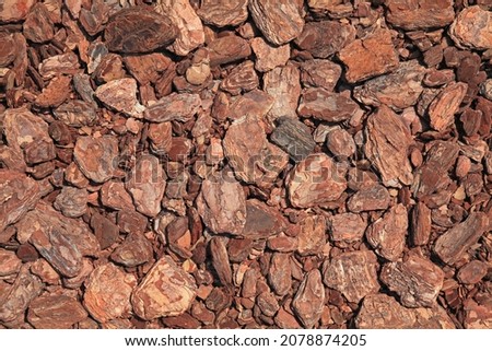 Abstract wooden, chaotic texture and background. Mosaic pattern of an innovative type of floor. Pine bark or mulch carpet. Timber product for the garden covering, relaxing zone or children playgrounds Royalty-Free Stock Photo #2078874205