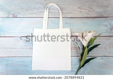 Tote bag canvas fabric cloth shopping sack mockup blank template on wooden background. Stock photo.