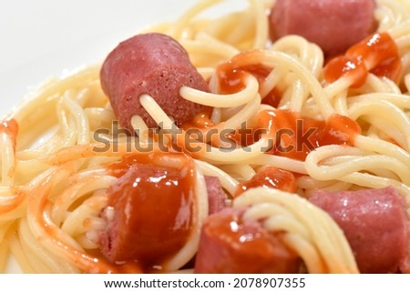 Close-up image of hot dog skewers and spaghetti with tomato ketchup    