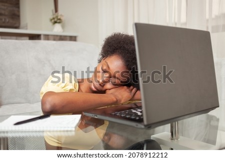 African American black woman freelancer sleeps in workplace near laptop, working at home, tired.
