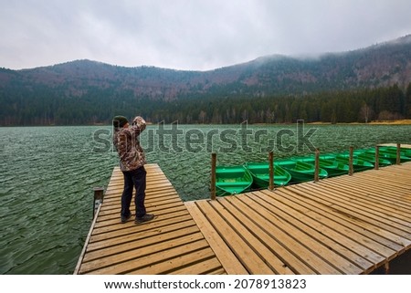 Tourist taking pictures of the landscape with St. Anne's Lake, Lake in Transylvania, Romania
