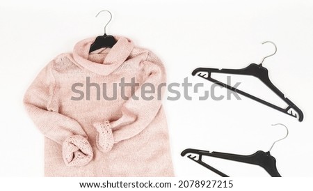 Hanger with stylish sweater on white background.