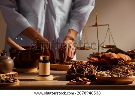 Traditional chinese medicine with herb and spices in brown wooden background and a doctor for advertising , chinese traditional medicine content 