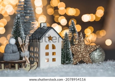 Happy New Year 2022. Beautiful background with a house, snow, sledges and Christmas trees in Scandinavian style. Celebrating the winter Christmas holidays. The concept of the beginning of the year.
