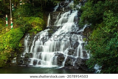 waterfall white stream flowing in deep green forests at evening long exposure shot image is taken on elephanta waterfall shillong meghalaya india. Royalty-Free Stock Photo #2078954503