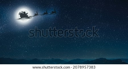 silhouette of a flying goth santa claus against the background of the christmas night sky.