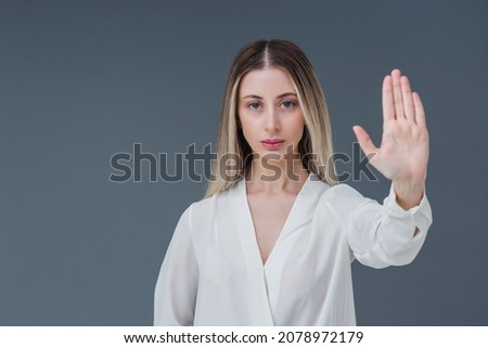 Beautiful blonde woman gesture and sign concept. She raised her hands and expressing stop the harassment abuse concept. Includes copy space.