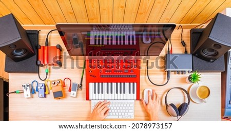 top view of professional music producer, composer hands arranging music on computer and recording equipments on desk. music production technology, home studio, e-learning concept Royalty-Free Stock Photo #2078973157