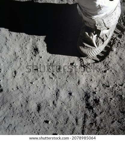 An Astronaut's stepping on the moon (lunar) surface and leaving a boot print. Elements of this image furnished by NASA.