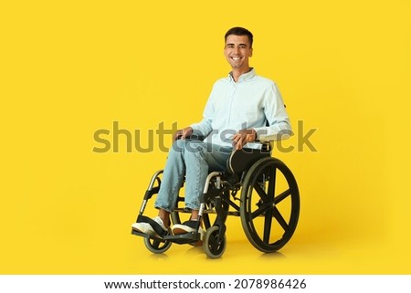 Young man in wheelchair on color background Royalty-Free Stock Photo #2078986426