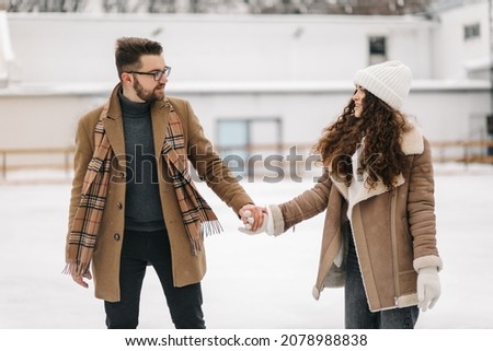 Portrait of two young people holding their hands in figure skating field