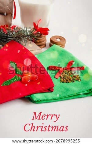 Merry Christmas text, Handmade gift boxes, milk for Santa, cookies, protective face mask with Xmas decoration on white background close up view. Winter holiday concept. Greeting card, frame