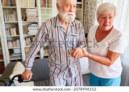 Geriatric nurse helps seniors with dementia in pajamas walking at home or in the nursing home Royalty-Free Stock Photo #2078996152
