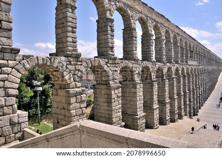 Roman aqueduct of Segovia on a sunny day with tourists visiting it