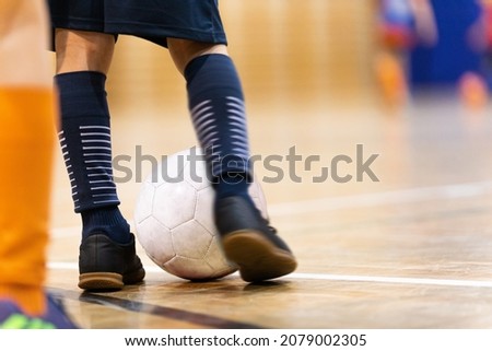 Indoor Football Training Session. Child Kicking Soccer Ball on Wooden Parquet Floor. Kids Practicing Soccer on Winter Time. Indoor Soccer Training. Futsal Ball and Training Court Royalty-Free Stock Photo #2079002305