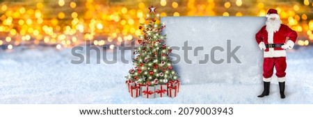 red white Santa claus with christmas tree gifts and empty copy space concrete pattern wall in front of snow warm golden bokeh lights background