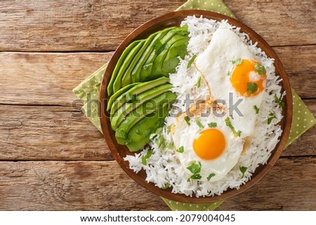Arroz con huevo frito is white rice and a fried egg close up in the plate on the table. Horizontal top view from above
 Royalty-Free Stock Photo #2079004045