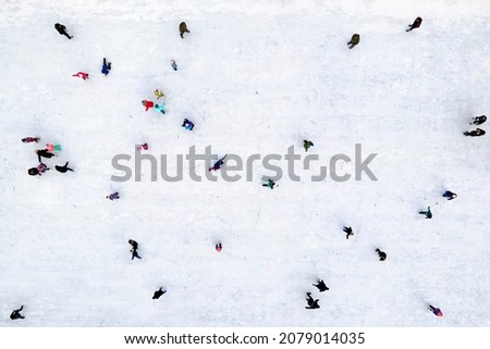 Ice skating top view. Children and their parents learn to skate on ice in winter. Winter fun. . Selective focus