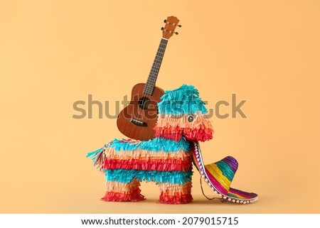 Mexican pinata in shape of horse, sombrero hat and guitar on color background