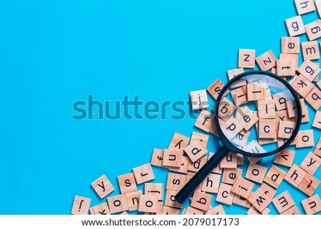 English alphabet made of square wooden tiles with the English alphabet scattered on blue background. The concept of thinking development,grammar. Royalty-Free Stock Photo #2079017173