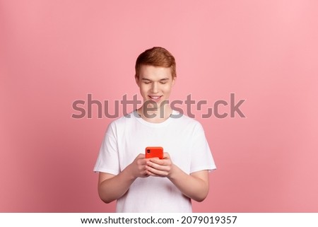 Photo of young man read post comment cellphone like follow subscribe isolated over pink color background