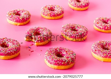 Sweet snacks - pink frosted donuts with colorful sprinkles
