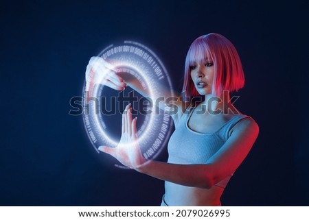 Woman in modern VR glasses interacting with network while having virtual reality experience. Augmented reality game, future technology, AI concept. VR. Holographic interface to display data.