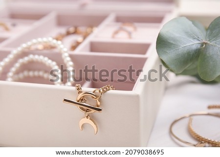 Jewelry box with stylish golden bijouterie on white table, closeup Royalty-Free Stock Photo #2079038695