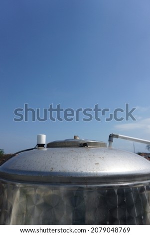 Gray water tank with a blue sky background