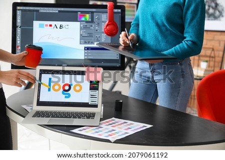 Female designer with colleague working in office Royalty-Free Stock Photo #2079061192