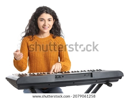 Young woman playing synthesizer on white background Royalty-Free Stock Photo #2079061258