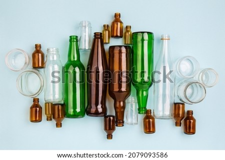 Separate collection of glass garbage. Colorful bottles and cans for recycle. Eco friendly concept. Recyclable glass waste on blue: empty glass jars and bottles. Zero waste. Save the planet. Go green Royalty-Free Stock Photo #2079093586