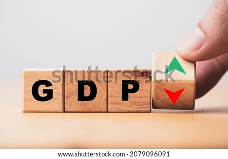 Hand flipping wooden cube block which print screen up and down symbol with GDP increase and decrease , GDP is Gross Domestic Product concept.
