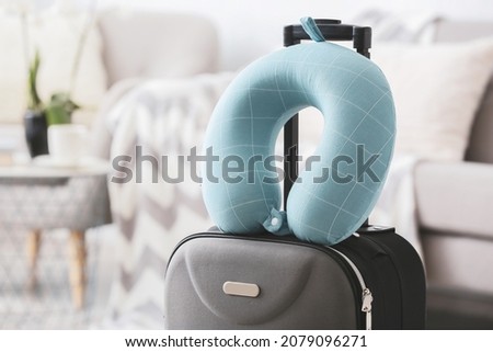 Travel pillow and suitcase in room Royalty-Free Stock Photo #2079096271