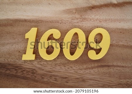 Golden Arabic numerals 1609 on a dark brown to white wood grain background.