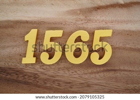 Golden Arabic numerals 1565 on a dark brown to white wood grain background.