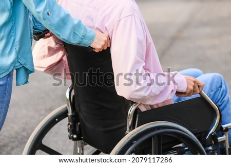 Young man with physical disability and his wife outdoors Royalty-Free Stock Photo #2079117286