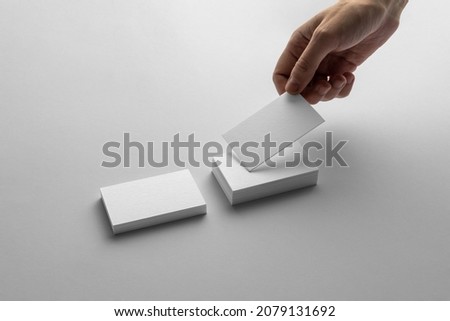 Hand holding business card, branding mockup template, minimalistic and clean, real photo. Blank isolated on a white background to place your design. 