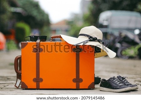 Orange vintage suitcase with travel accessories for travel or holiday concept 